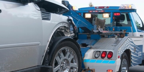 Wrecked car being pulled by tow truck